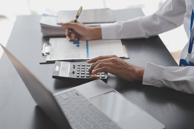 Portret van jonge Aziatische vrouw hand freelancer werkt haar werk op een computer tablet in een modern kantoor Het doen van boekhoudkundige analyse rapport vastgoed investeringen gegevens Financiële en belasting systemen concept