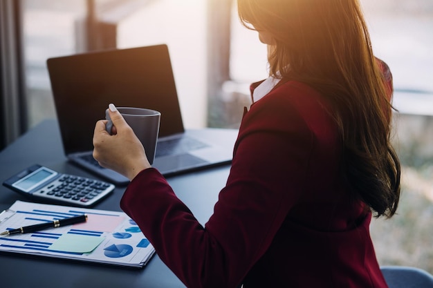 Portret van jonge Aziatische vrouw hand freelancer werkt haar werk op een computer tablet in een modern kantoor Het doen van boekhoudkundige analyse rapport vastgoed investeringen gegevens Financiële en belasting systemen concept