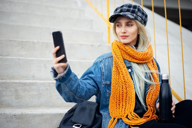 Portret van jonge blonde tienermeisje, selfie foto met smartphone