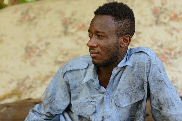 Portret van jonge dakloze Afrikaanse man in de straten buitenshuis