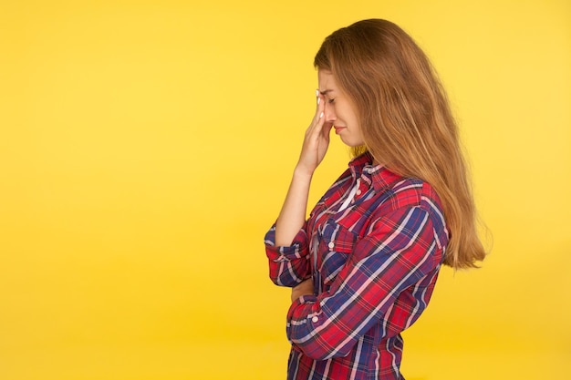 Portret van jonge emotionele vrouw op gele achtergrond