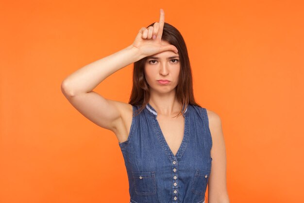 Portret van jonge emotionele vrouw op oranje achtergrond