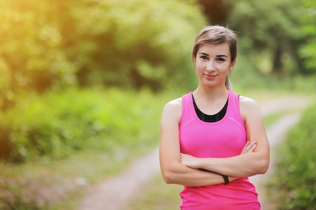 Foto portret van jonge fitness vrouw in de ochtend bos. gezond fit leven