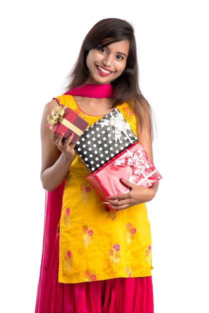 Portret van jonge gelukkig lachend Indiase meisje met geschenkdozen op een witte achtergrond.