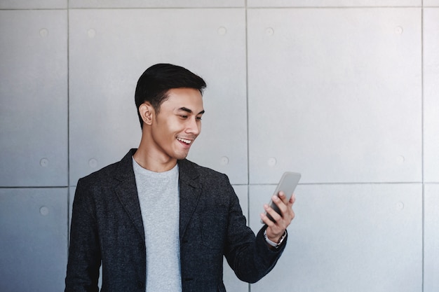 Portret van jonge gelukkig zakenman met behulp van Smartphone