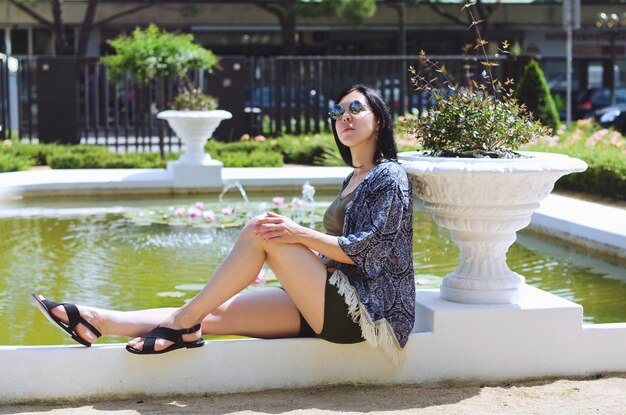 Foto portret van jonge gelukkige brunette aziatische vrouw ontspannen in de stad park meer zomervakantie reis