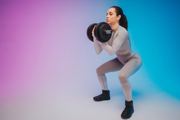 Portret van jonge geschikte en sportieve Kaukasische vrouw op gradiëntachtergrond