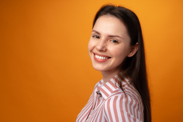 Portret van jonge glimlachende donkerbruine vrouw in studio