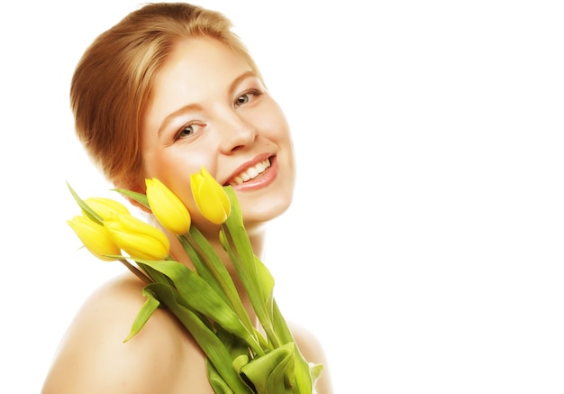 Portret van jonge glimlachende vrouw met gele tulpen