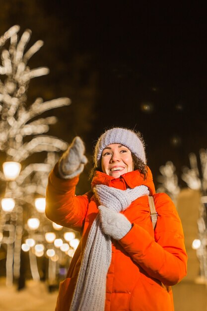 Portret van jonge grappige aantrekkelijke vrouw over besneeuwde kerst achtergrond wintervakanties en seizoen