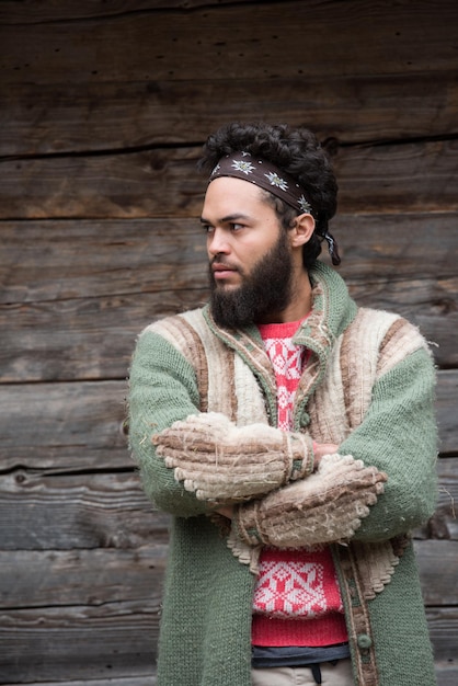 Foto portret van jonge hipster, man met baard voor oud vintage houten huis