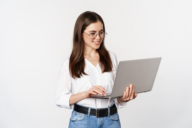 Portret van jonge kantoorvrouw ondernemer antwoord klanten op laptop werken met computer met happ...