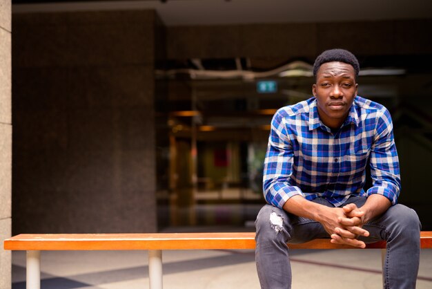 Portret van jonge knappe Afrikaanse man in de straten van de stad buitenshuis