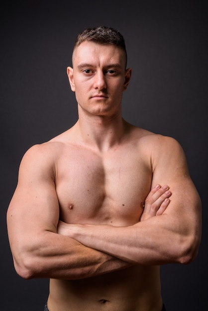 Portret van jonge knappe gespierde fitness man shirtless met gekruiste armen