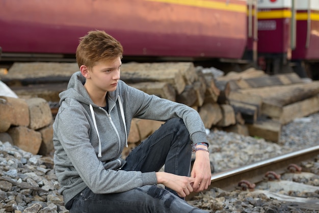 Portret van jonge knappe tiener bij het treinstation