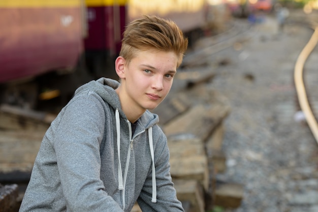 Foto portret van jonge knappe tiener bij het treinstation