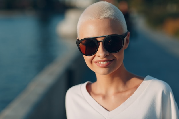 Portret van jonge lachende millenial Europese kortharige vrouw in zonnebril mooie gelukkige blonde...