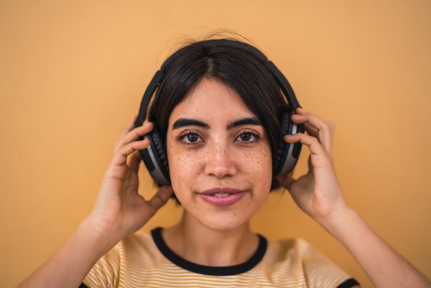 Portret van jonge Latijns-vrouw, luisteren naar muziek met een koptelefoon