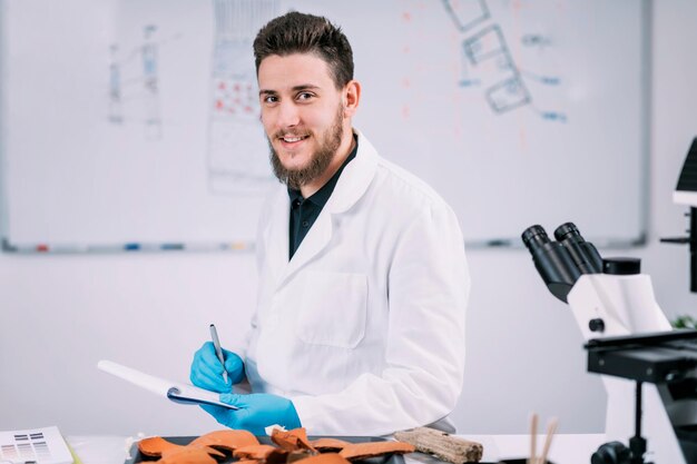 Foto portret van jonge mannelijke archeologiestudent in laboratorium