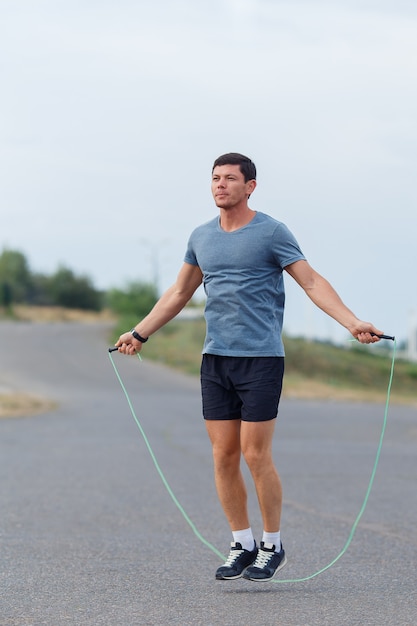 Portret van jonge mannelijke atleet springtouw.