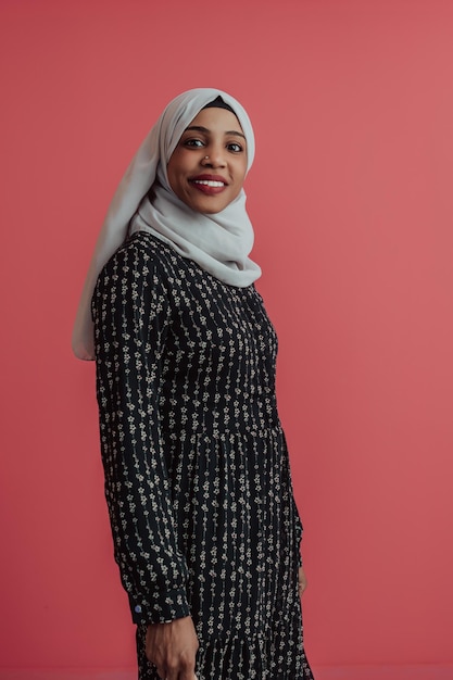 Portret van jonge moderne moslimschoonheid die traditionele islamitische kleding draagt op plastic roze achtergrond. Selectieve aandacht. Foto van hoge kwaliteit