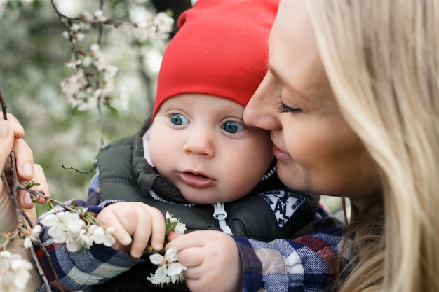 Foto portret van jonge moeder met blonde baby buitenshuis. gelukkig gezin. mama met baby.