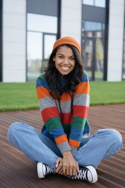 Portret van jonge mooie African American vrouw buiten zitten