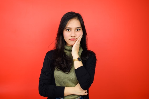 Portret van jonge mooie Aziatische vrouwen met zwarte trui met rode geïsoleerde achtergrond
