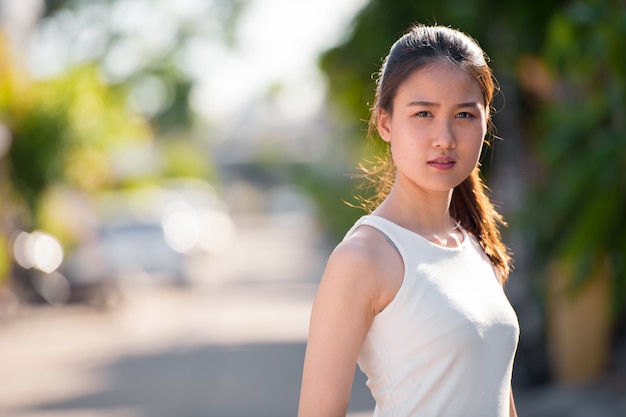 Portret van jonge mooie Aziatische zakenvrouw in de straten buiten