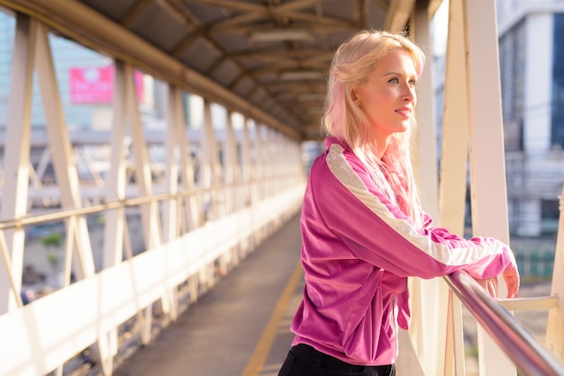 Portret van jonge mooie blonde vrouw bij loopbrug in de stad buiten