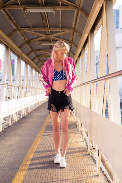 Portret van jonge mooie blonde vrouw bij loopbrug in de stad buiten