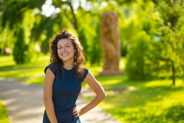 Portret van jonge mooie brunette geniet van een heldere zomerdag in het groene park