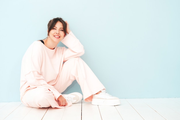 Portret van jonge mooie glimlachende vrouw in trendy roze zomerkleding