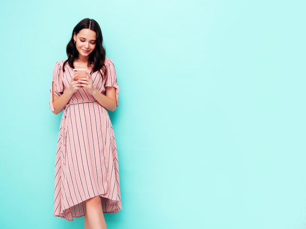 Portret van jonge mooie lachende vrouw in trendy roze zomerjurk Sexy zorgeloze vrouw poseren in studio Positief model plezier binnenshuis Vrolijk en gelukkig