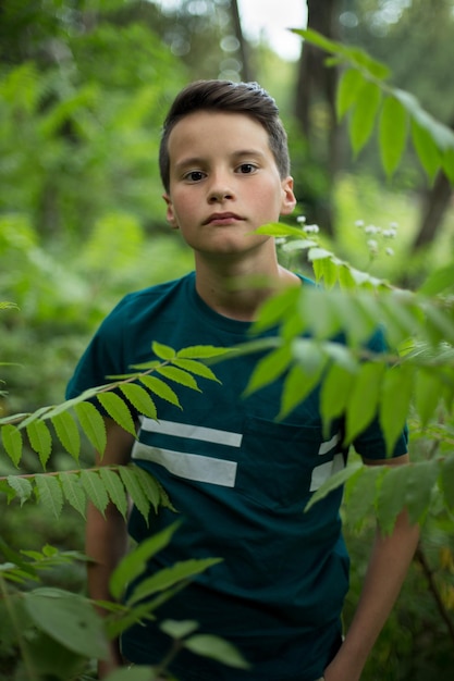 Portret van jonge mooie tienerjongen in bos