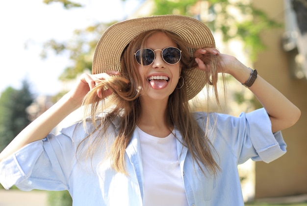 Portret van jonge mooie trendy meisje poseren in de stad, zomer straatmode.