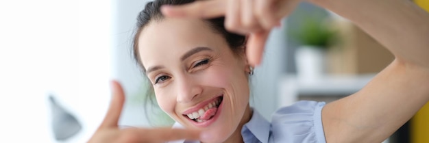 Portret van jonge mooie vrouw die frame met eigen handen maakt