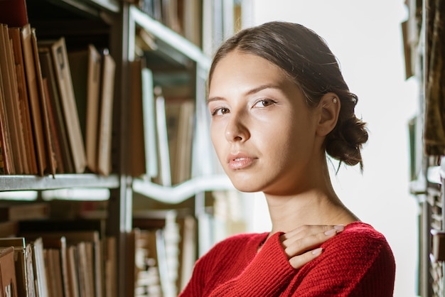 Portret van jonge mooie vrouw in bibliotheek