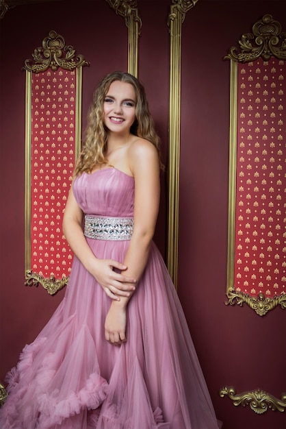 portret van jonge mooie vrouw in lange roze jurk