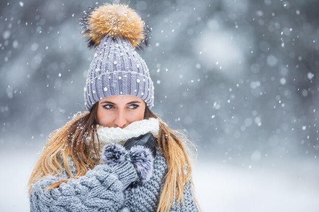 Portret van jonge mooie vrouw in winterkleren en sterk sneeuwt.