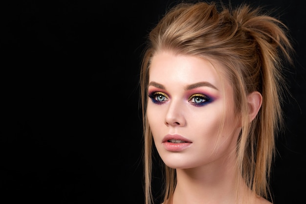 Portret van jonge mooie vrouw met avond make-up poseren. rode en gouden veelkleurige smokey eyes. luxe huidverzorging en modern mode-make-upconcept.