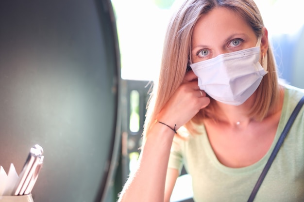 Foto portret van jonge mooie vrouw met beschermend masker op straat