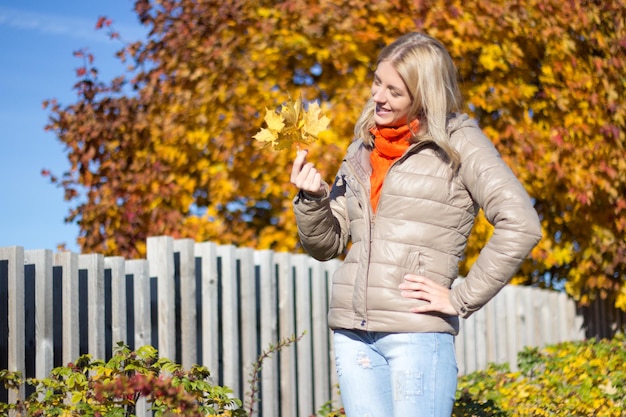 Portret van jonge mooie vrouw met boeket van esdoornbladeren in de herfstpark