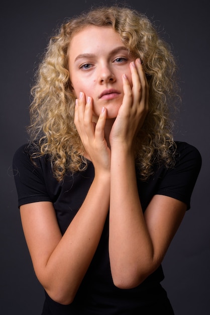 Portret van jonge mooie vrouw met krullend blond haar