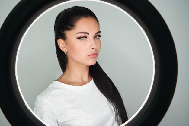 Portret van jonge mooie vrouw met ringflits ronde led cirkellamp in studio