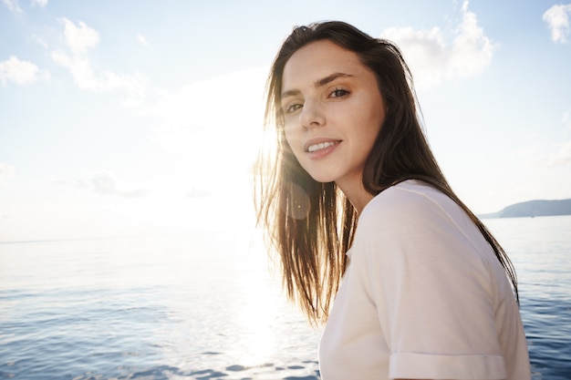 Portret van jonge mooie vrouw staande op de boot tegen zee backgorund