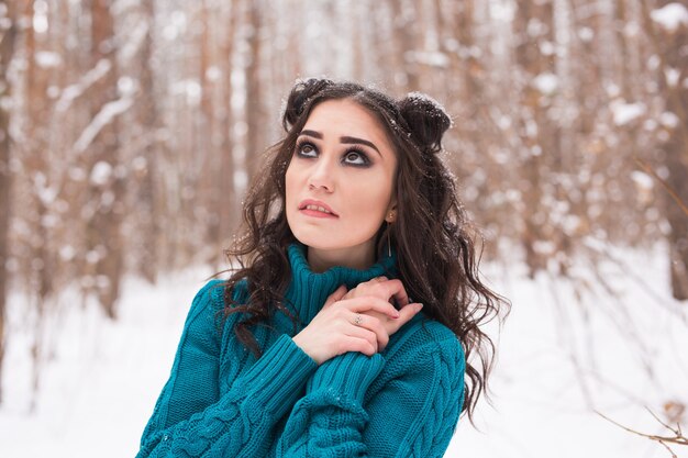 Portret van jonge mooie vrouw wandelen in het besneeuwde winterpark