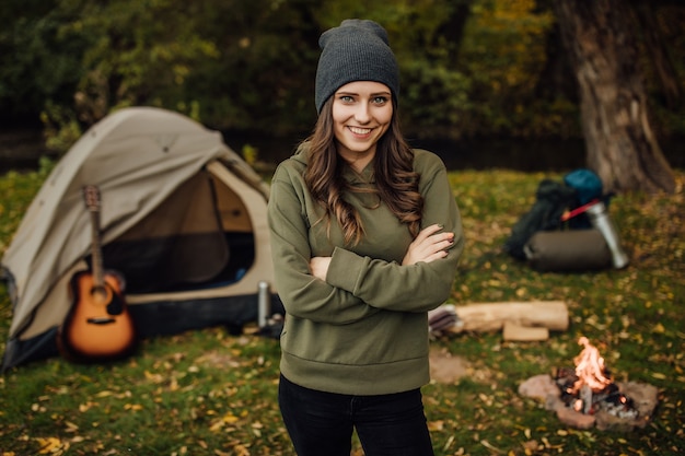 Portret van jonge mooie vrouwelijke toerist in het bos in de buurt van tent