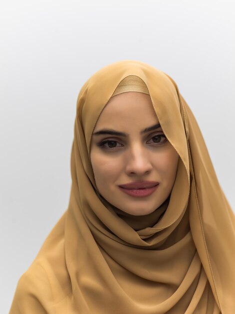 Portret van jonge moslimvrouw die hijab op geïsoleerde witte achtergrond draagt.