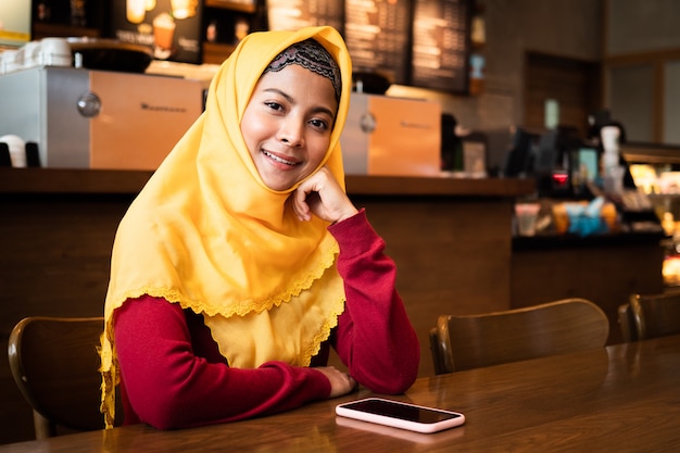 Portret van jonge moslimvrouw in coffeeshop